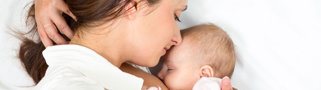 new-mom-with-newborn-in-bed-face-to-face